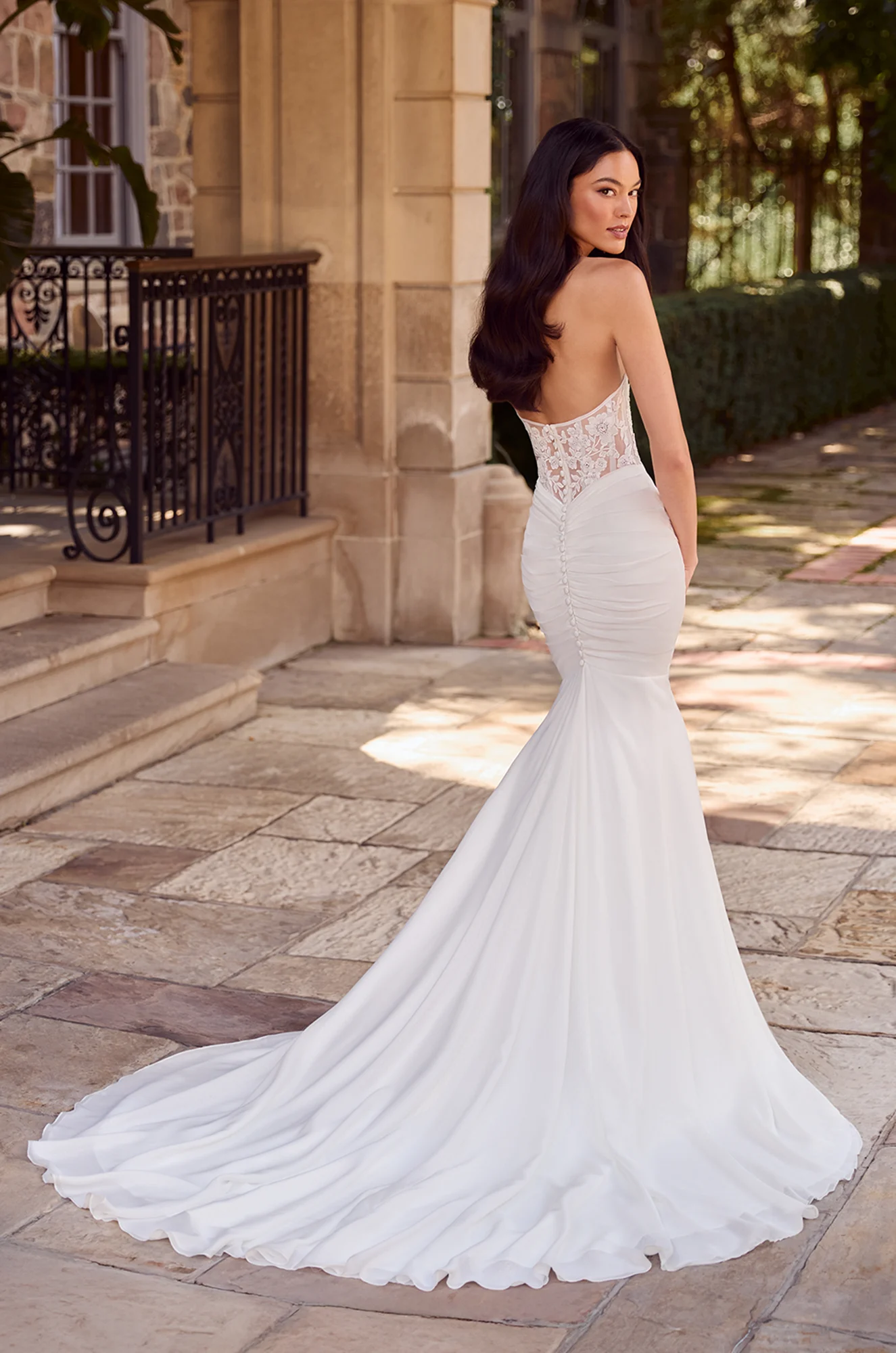 Fitted mermaid gown with sheer lace corset back, button details, and a soft chapel train for timeless allure.