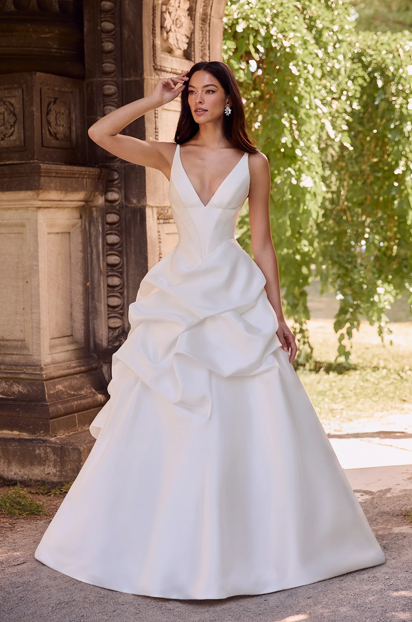 Satin ball gown with deep V-neckline, fitted bodice, and cascading ruffled skirt creating a dramatic, sculpted silhouette.