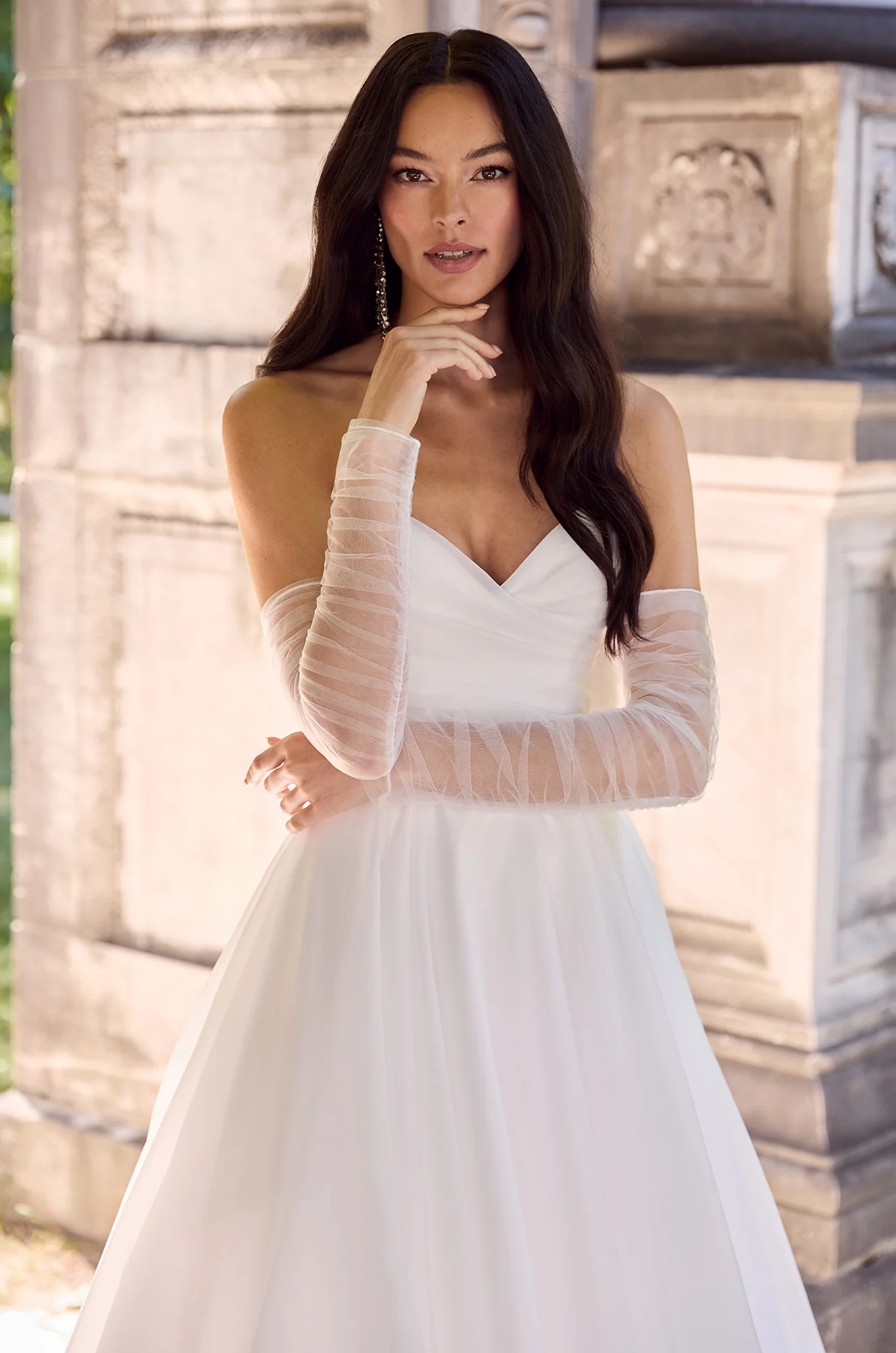 Wedding dress close-up showing sweetheart neckline and long sleeve tulle bodice detail.