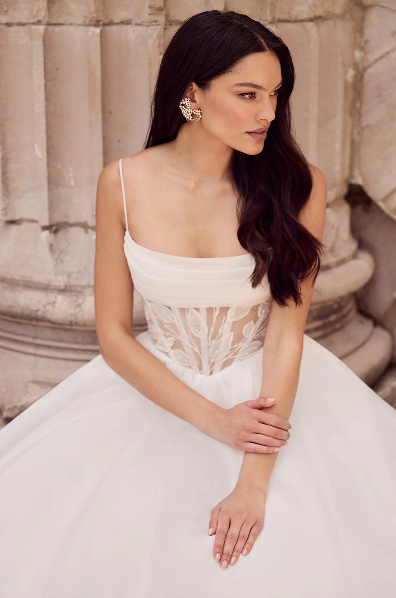 Wedding dress close-up showing sheer corset bodice detail with intricate beading design.
