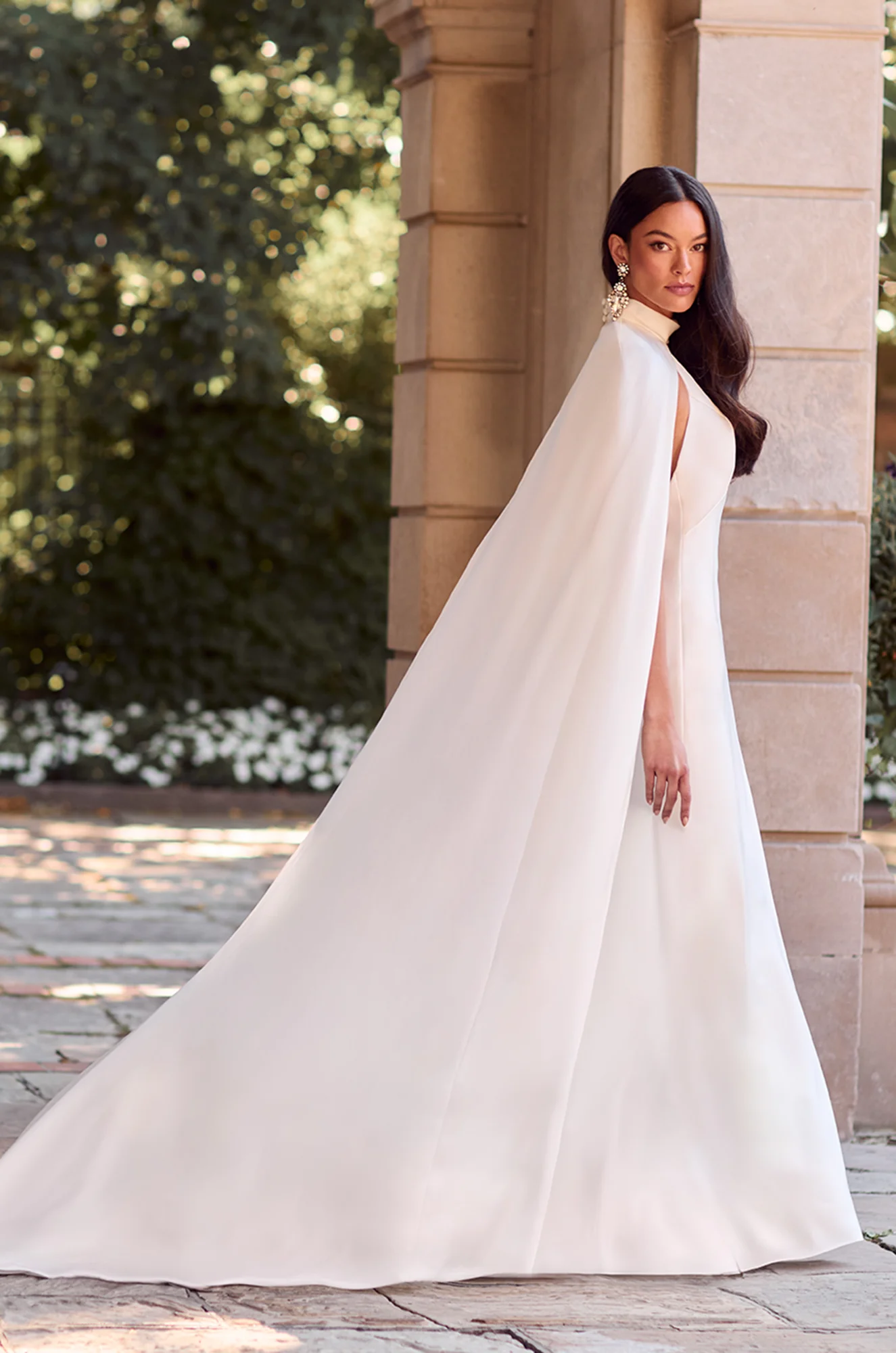 Wedding dress side profile showing V-neckline, cape detail and fitted silhouette.