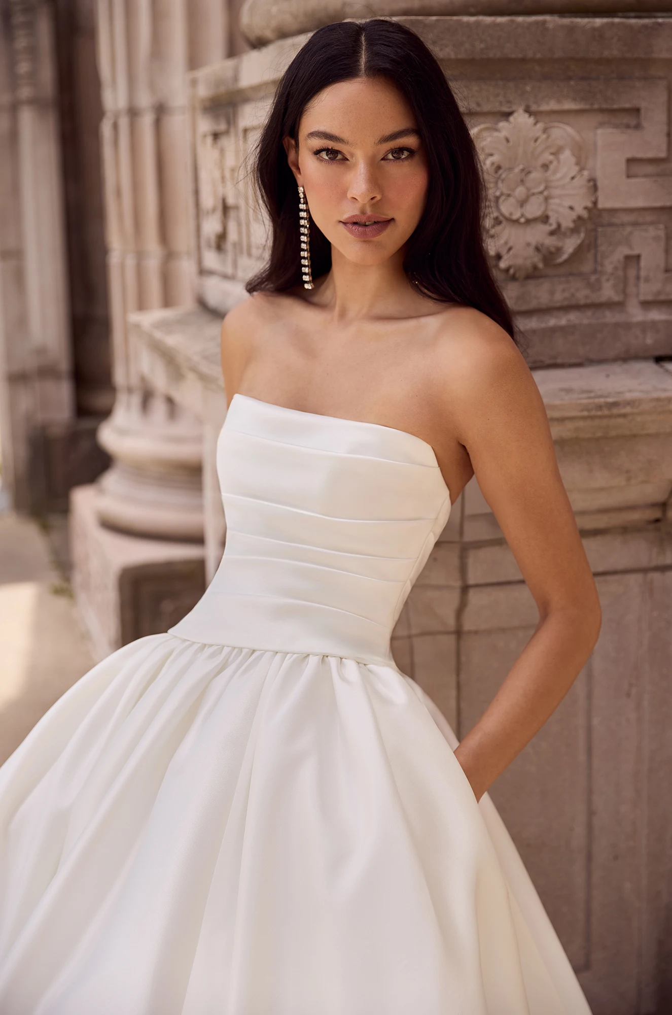 Wedding dress close-up showing strapless ruched bodice and fitted waist detail.