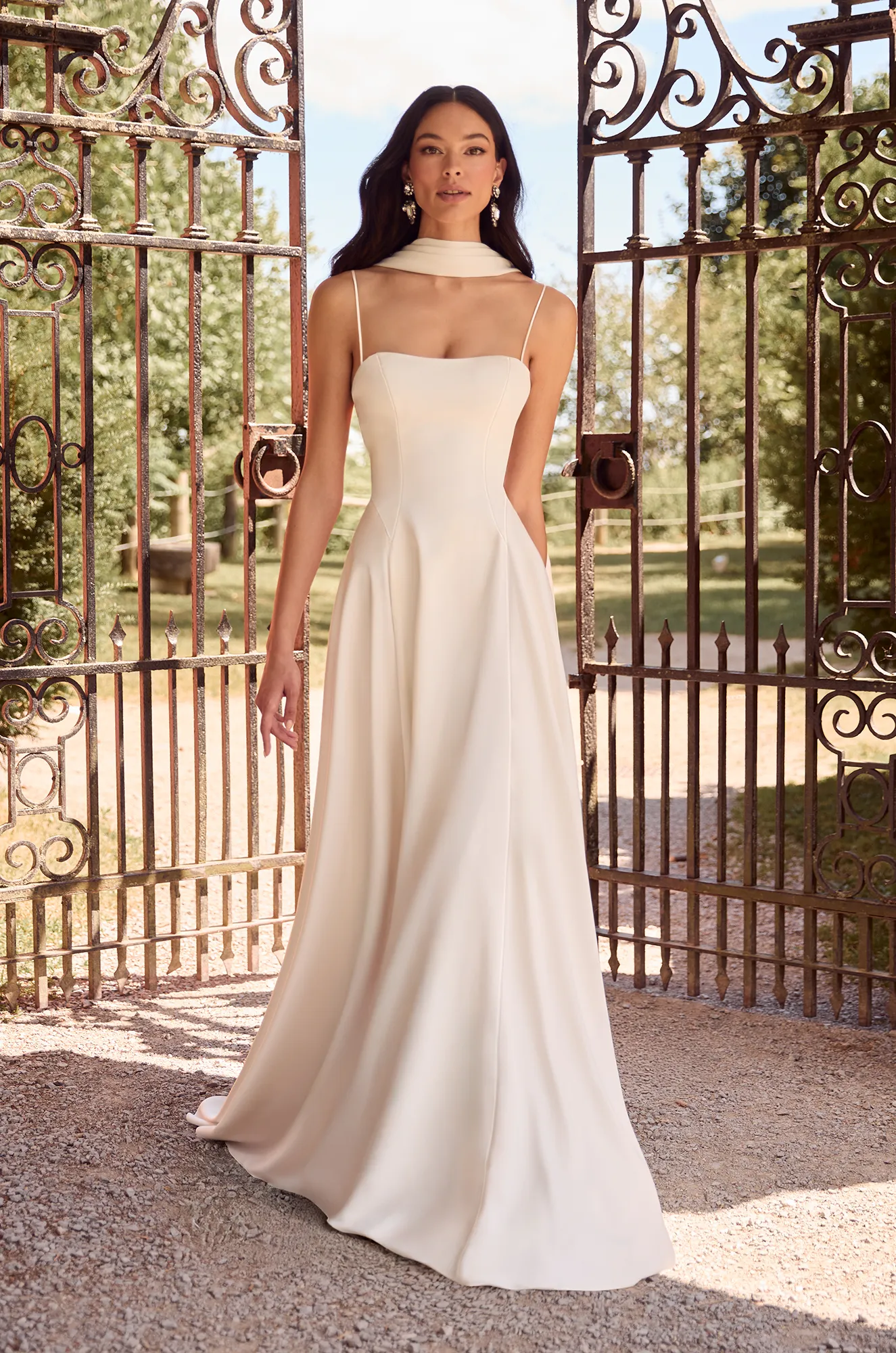 Simple satin gown with thin straps, square neckline, and flowing A-line skirt for a modern, refined look.