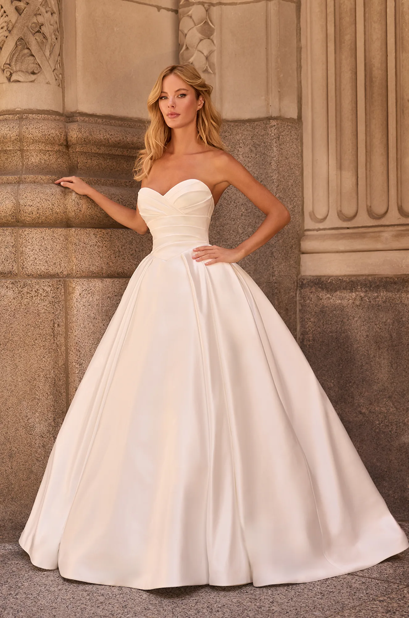 Elegant strapless satin ball gown with a sweetheart neckline, fitted ruched bodice, and full pleated skirt for a timeless look.