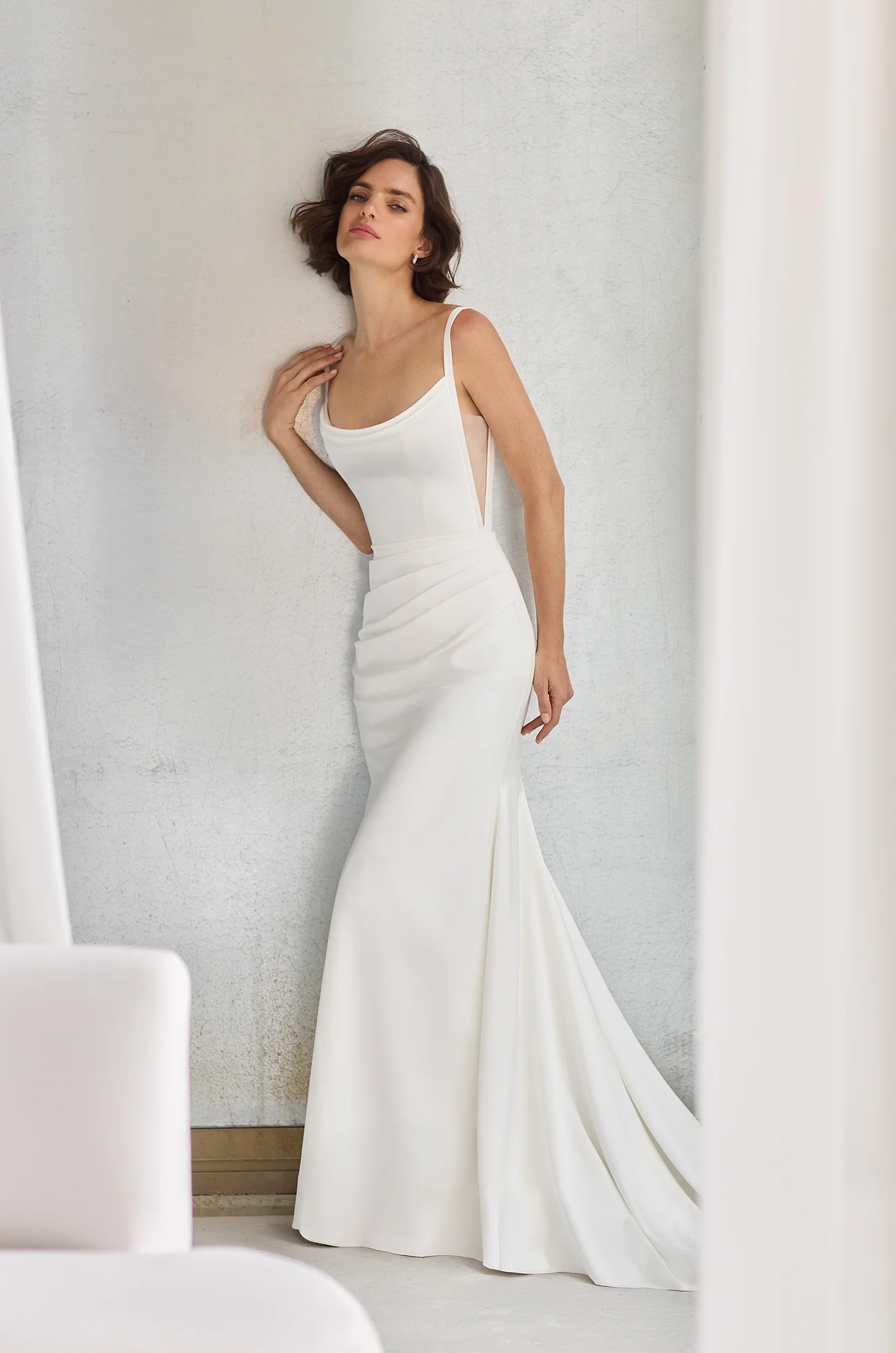 Sleeveless Charmeuse gown with a draped scoop neckline and V-shaped cut outs on the sides of the bodice, with a draped fit and flare skirt.
