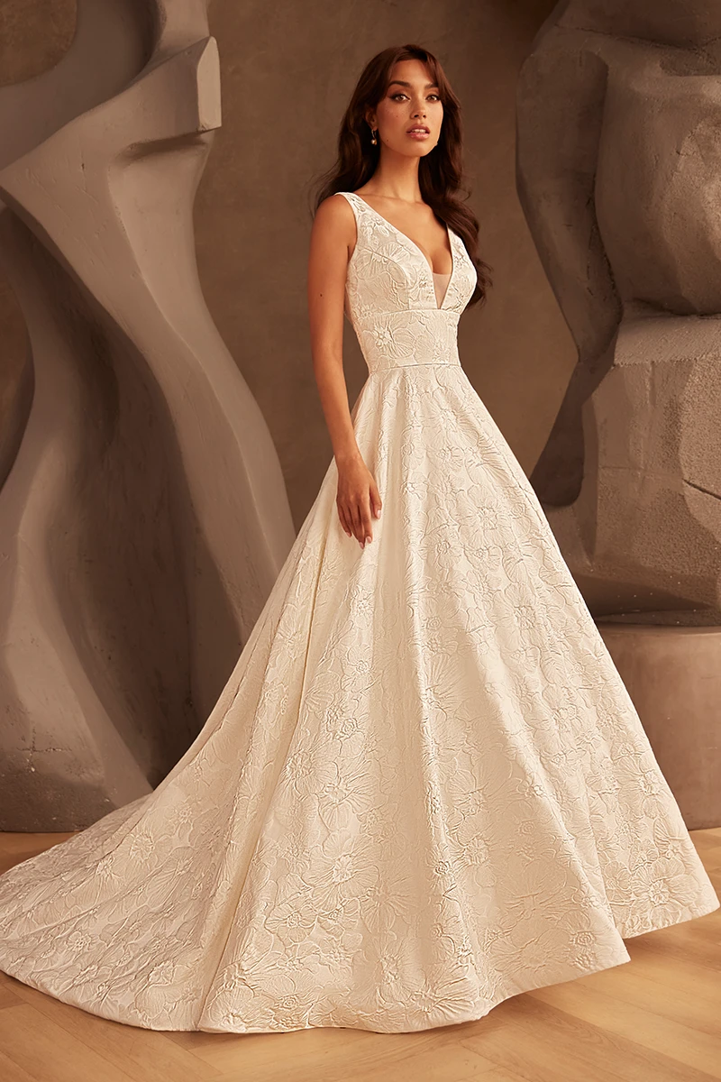 V-neckline embroidered wedding dress with floral pattern, fitted waist and ball gown train. 