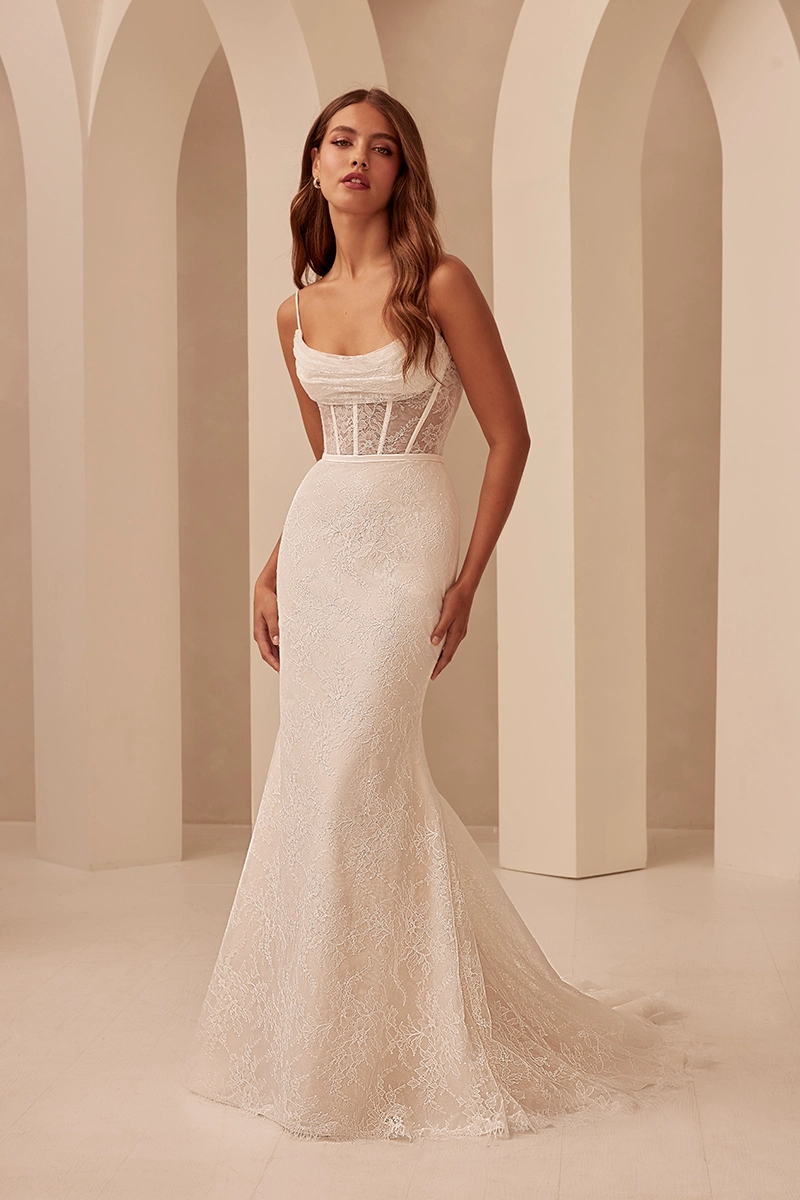 Lace wedding gown with corset bodice, draped neckline, and fitted flare skirt detailed with soft floral lace.