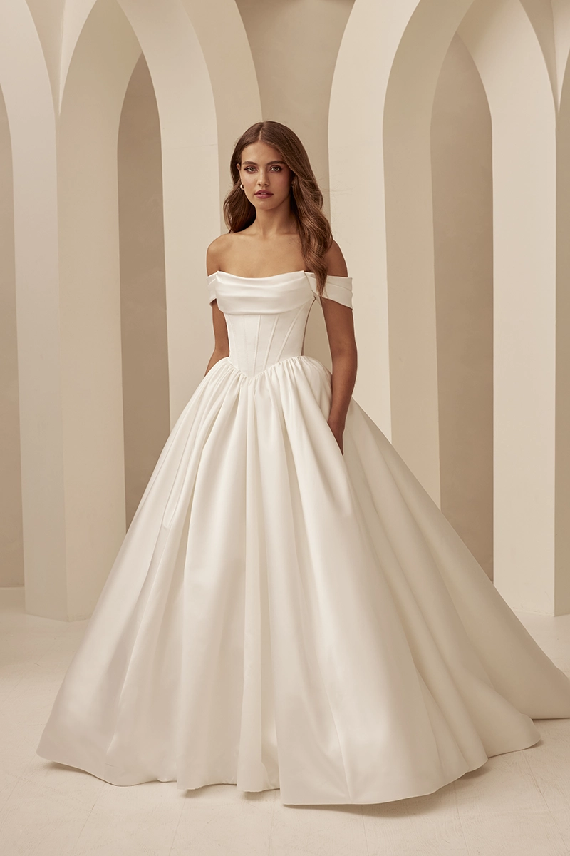Off-shoulder satin ball gown with draped foldover neckline, and voluminous full gathered skirt with pockets.