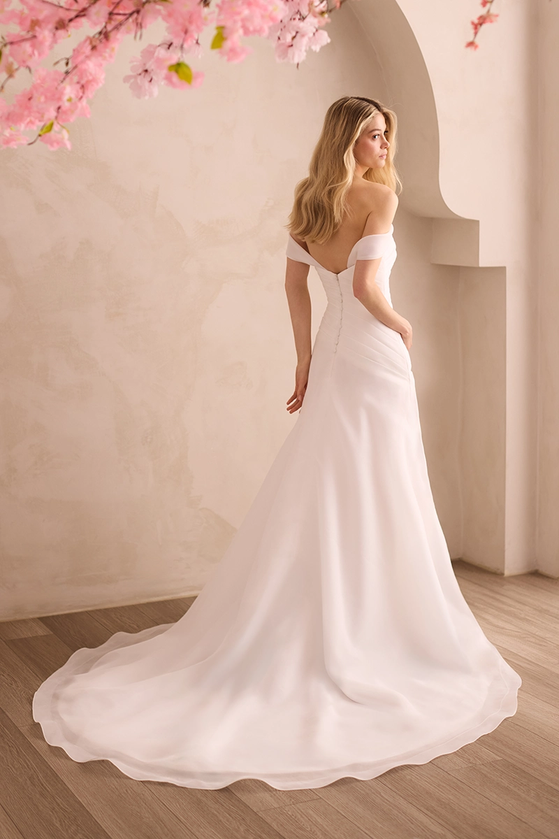 Organdy gown with asymmetric pleated bodice, draped sleeves, and a draped A-line skirt.