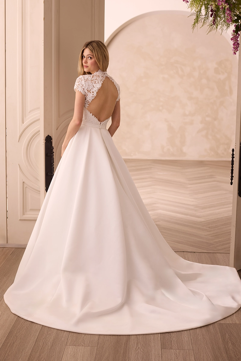 Lace and Satin gown with a jewel neckline, cap sleeves, and a keyhole back on the bodice, and a Satin A-line skirt with pockets.