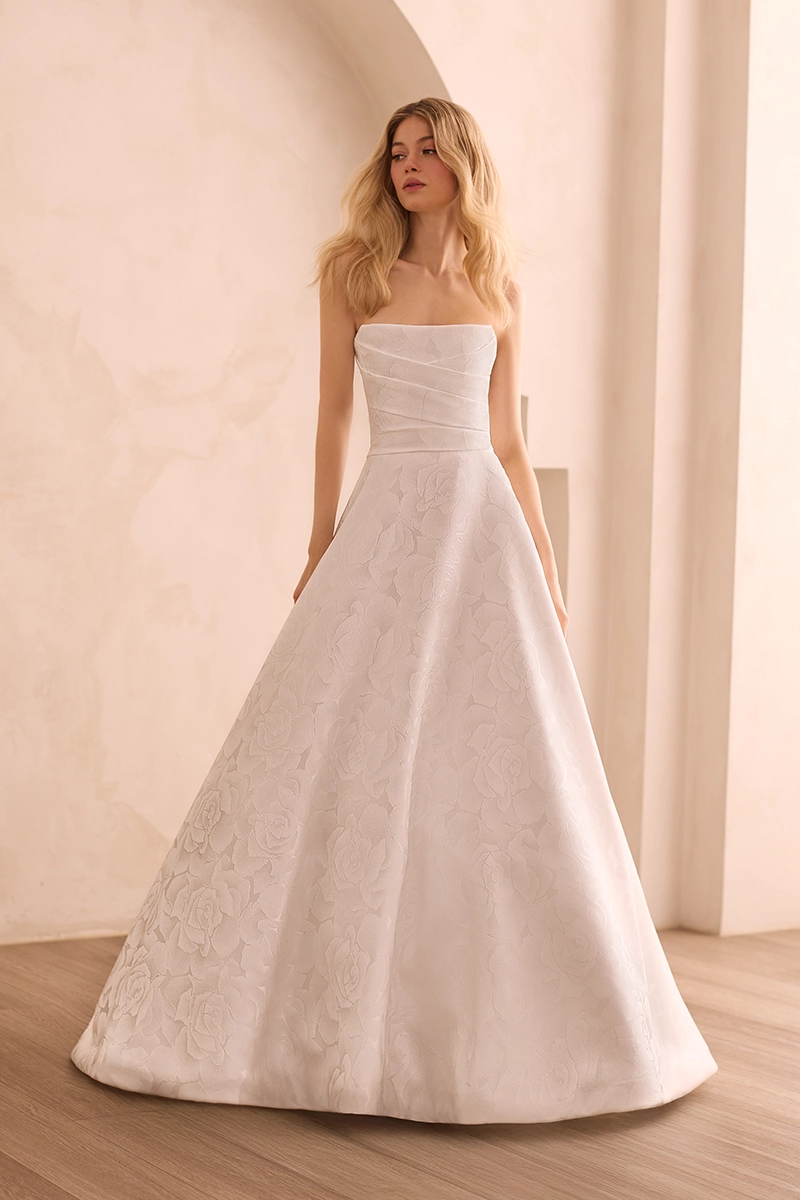 Strapless scoop neckline Jacquard gown with a pleated bodice and an A-line skirt with pockets.