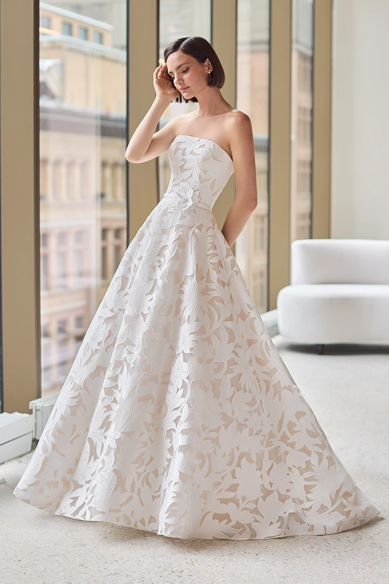 Lace gown with a strapless bodice, straight neckline and an A-line skirt with pockets.