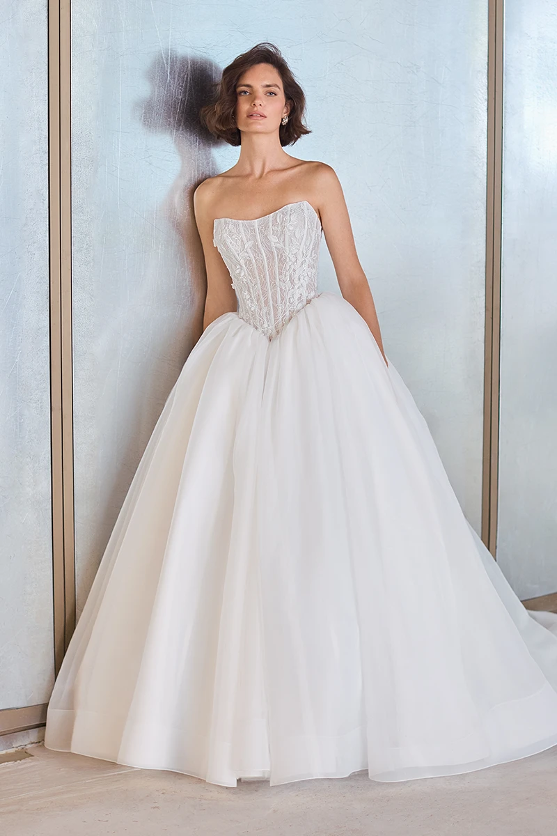 Lace and Organza gown with a strapless sheer Lace bodice, a low basque waistline, and a gathered Organza ball gown skirt.
