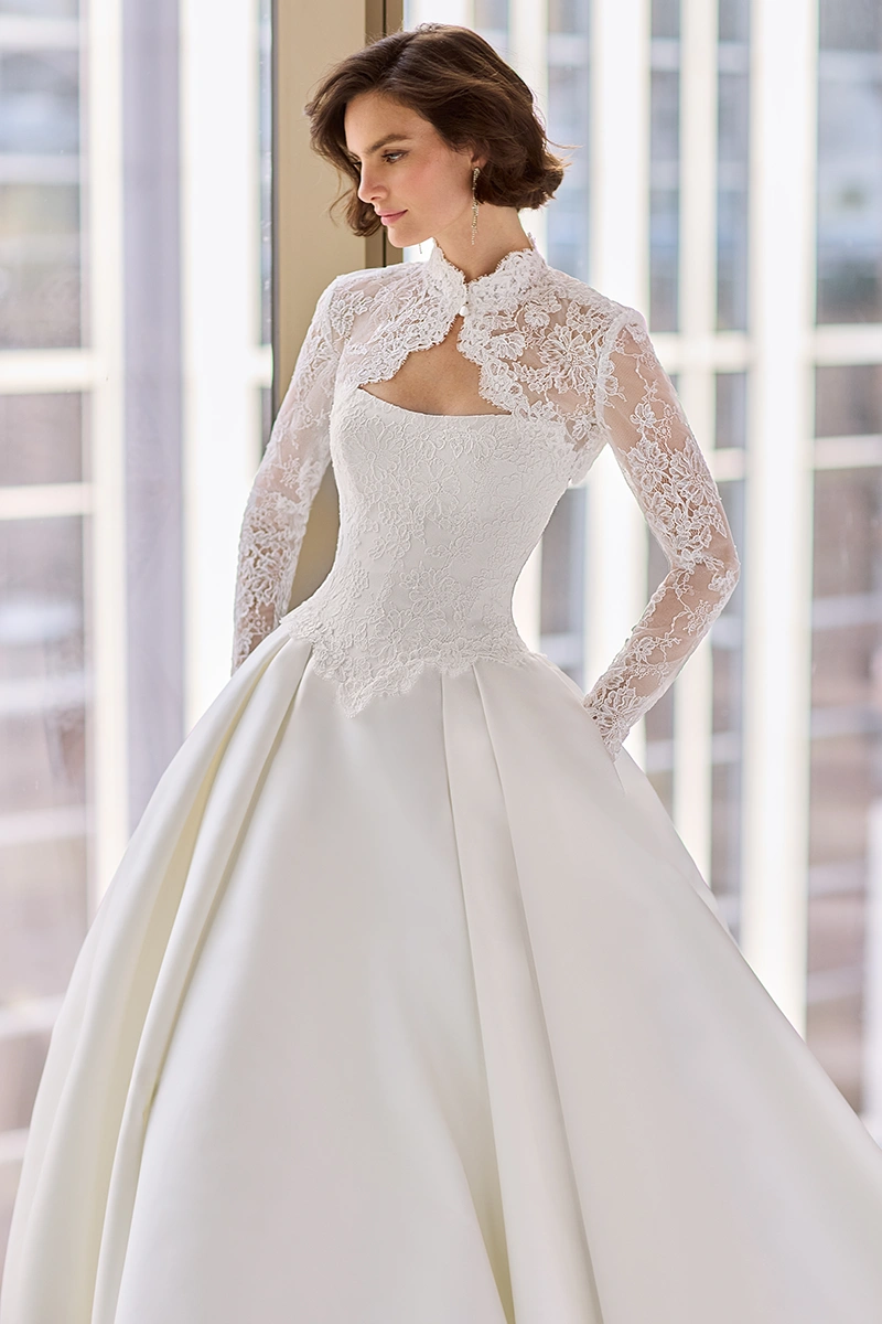 Strapless Lace and Satin gown with a scoop neckline and pleated ball gown skirt, and a long sleeve Lace bolero with a keyhole back.