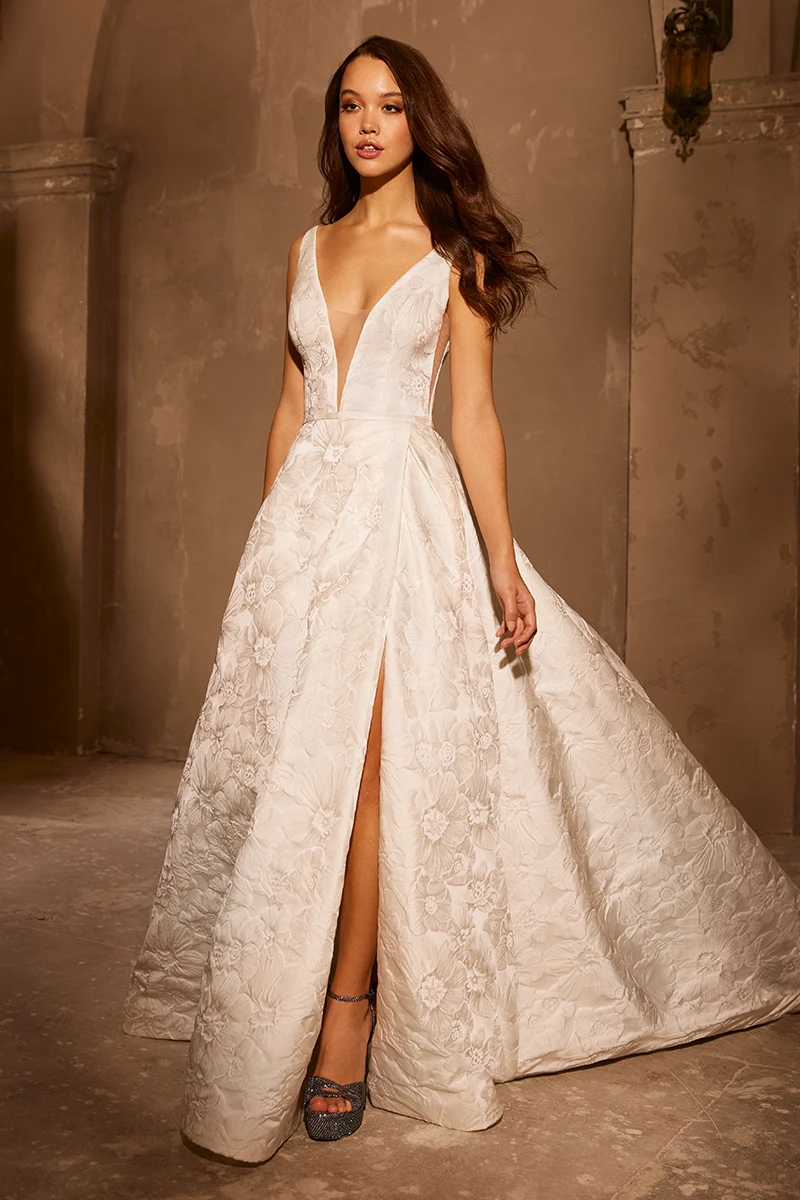 Plunging V-neckline floral Brocade wedding dress with high slit, fitted bodice and ball gown.