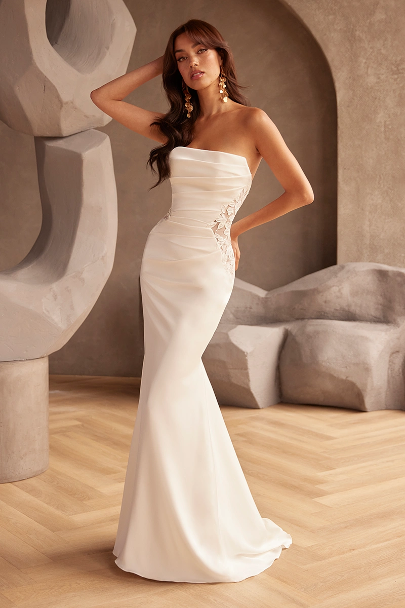 Strapless satin wedding gown with fitted silhouette, ruched bodice and sheer floral lace side panels.