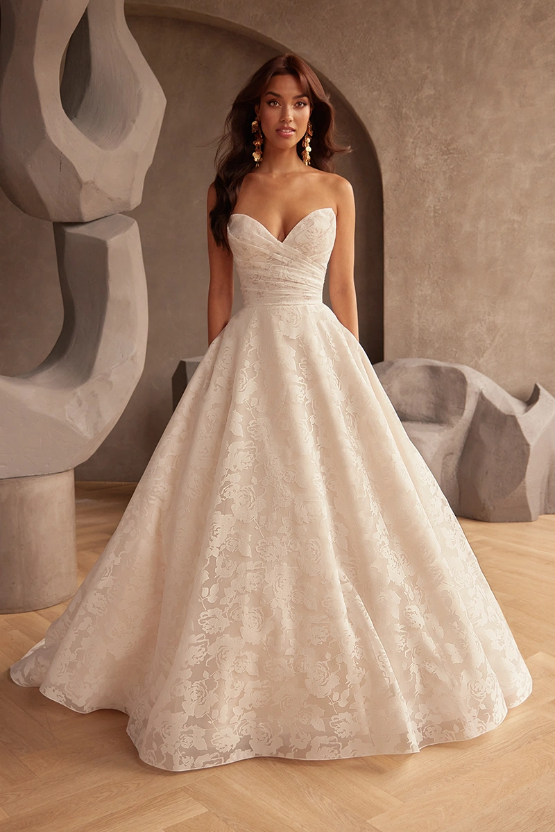 Strapless sweetheart ball gown featuring a ruched bodice and full floral A-line skirt for a textured, timeless look.