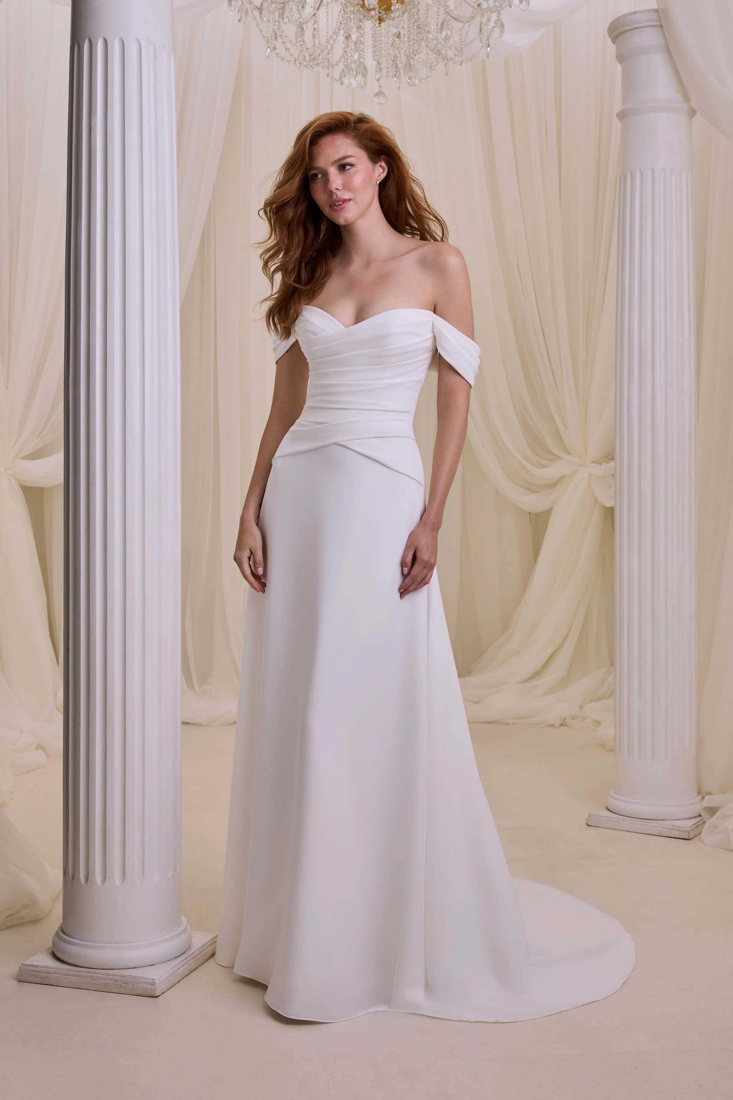 Strapless drop waisted Crêpe gown with a draped bodice, cat-eye V-neckline, and draped sleeves, with an A-line skirt.
