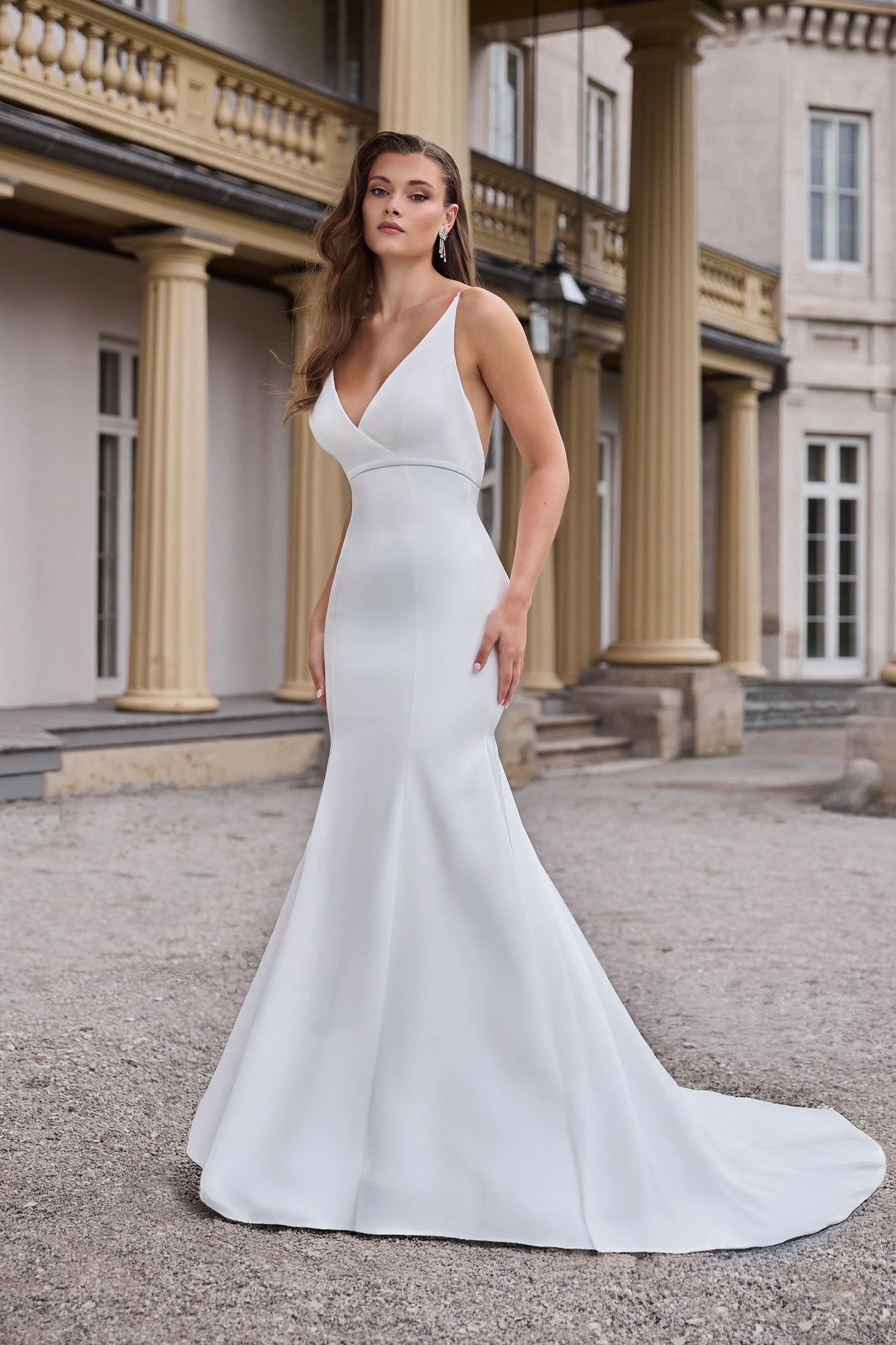 V-neck sleeveless Charmeuse gown with an empire waist, fitted skirt, and back bow.