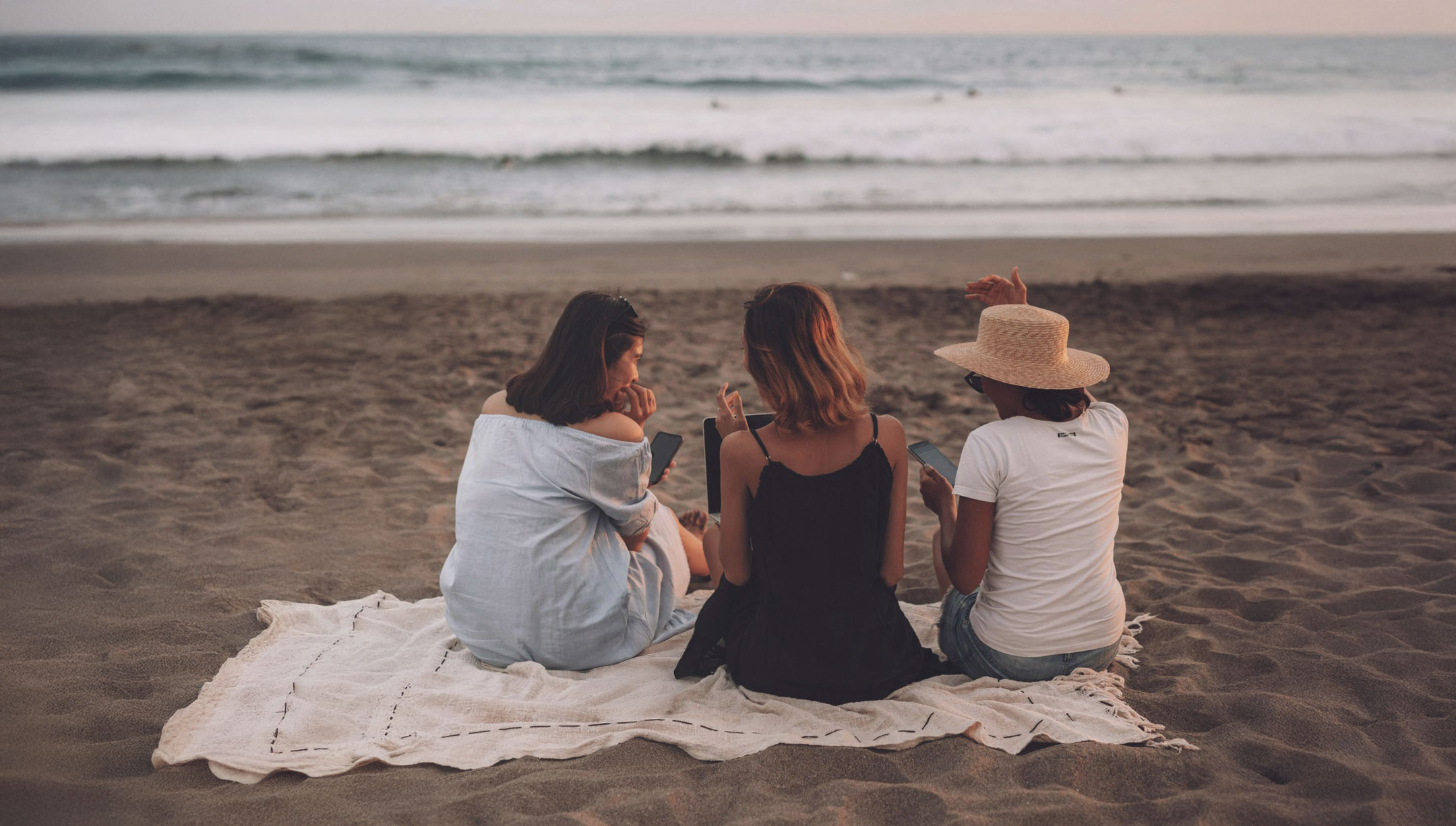 Trois personnes travaillant sur la plage face à l’océan