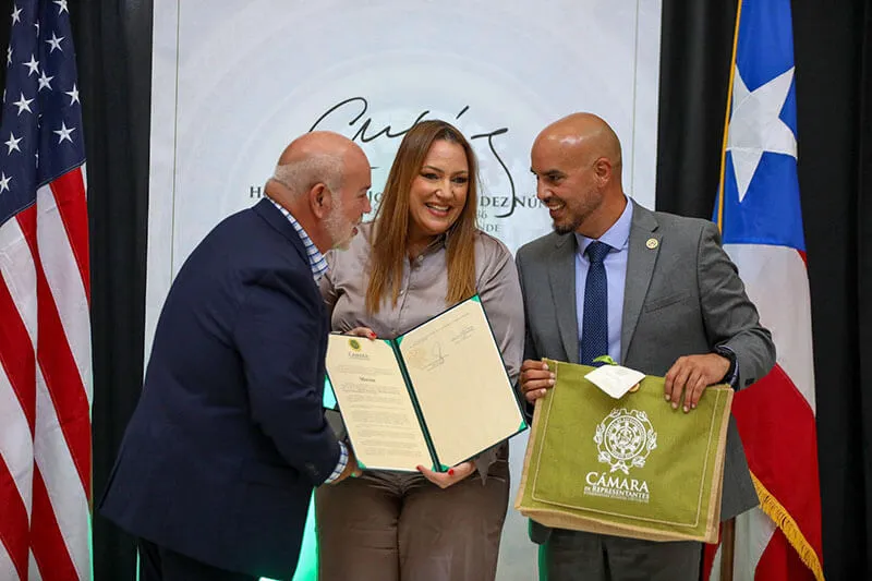 Carlos Johnny Méndez and José Aníbal "Joey" Meléndez Chamber presenting recognition to Ms. Betancourt