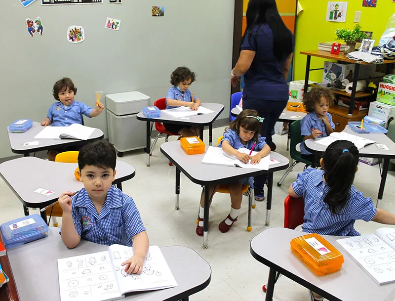 Girls and boys in a classroom next to the teacher