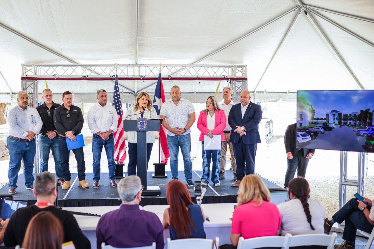 La gobernadora, Jenniffer González Colón junto con parte del equipo en tarima dando un discurso.