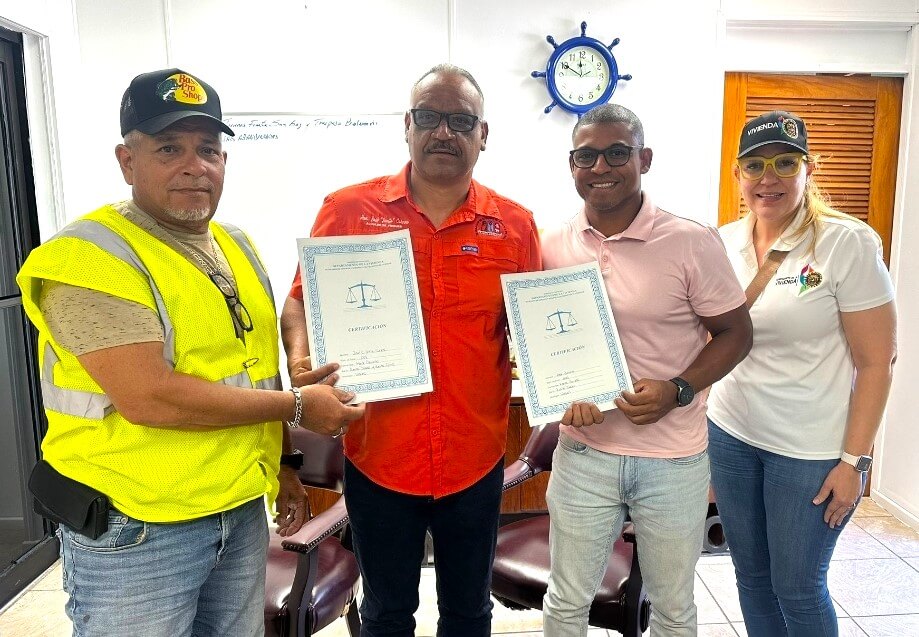 Mrs. Omayra Betancourt Colon and Mr. José Collazo deliver property titles to Mr. Alex Genera and Mr. José C. Ortiz