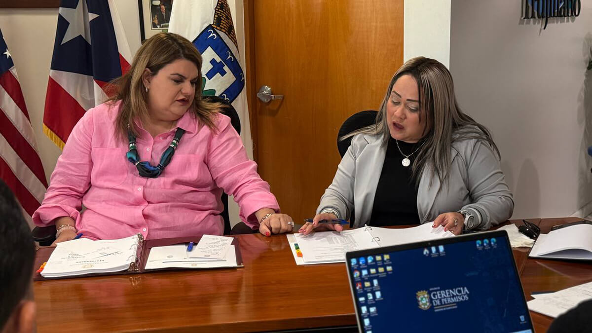 Jenniffer González Colón y Ciary Pérez Peña mirando un documento en el escritorio.