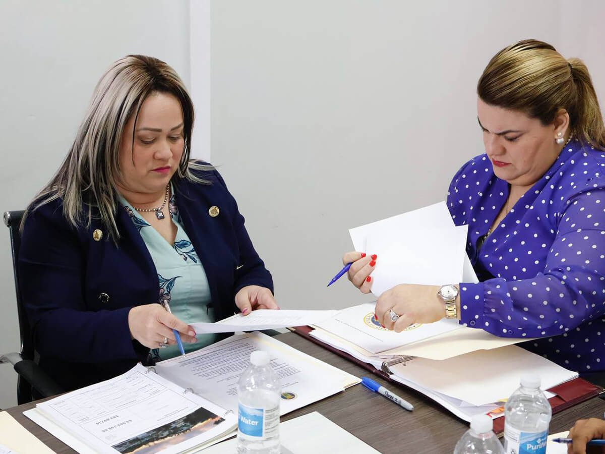 Jenniffer González Colón y Ciary Pérez Peña leyendo documentos en mano.