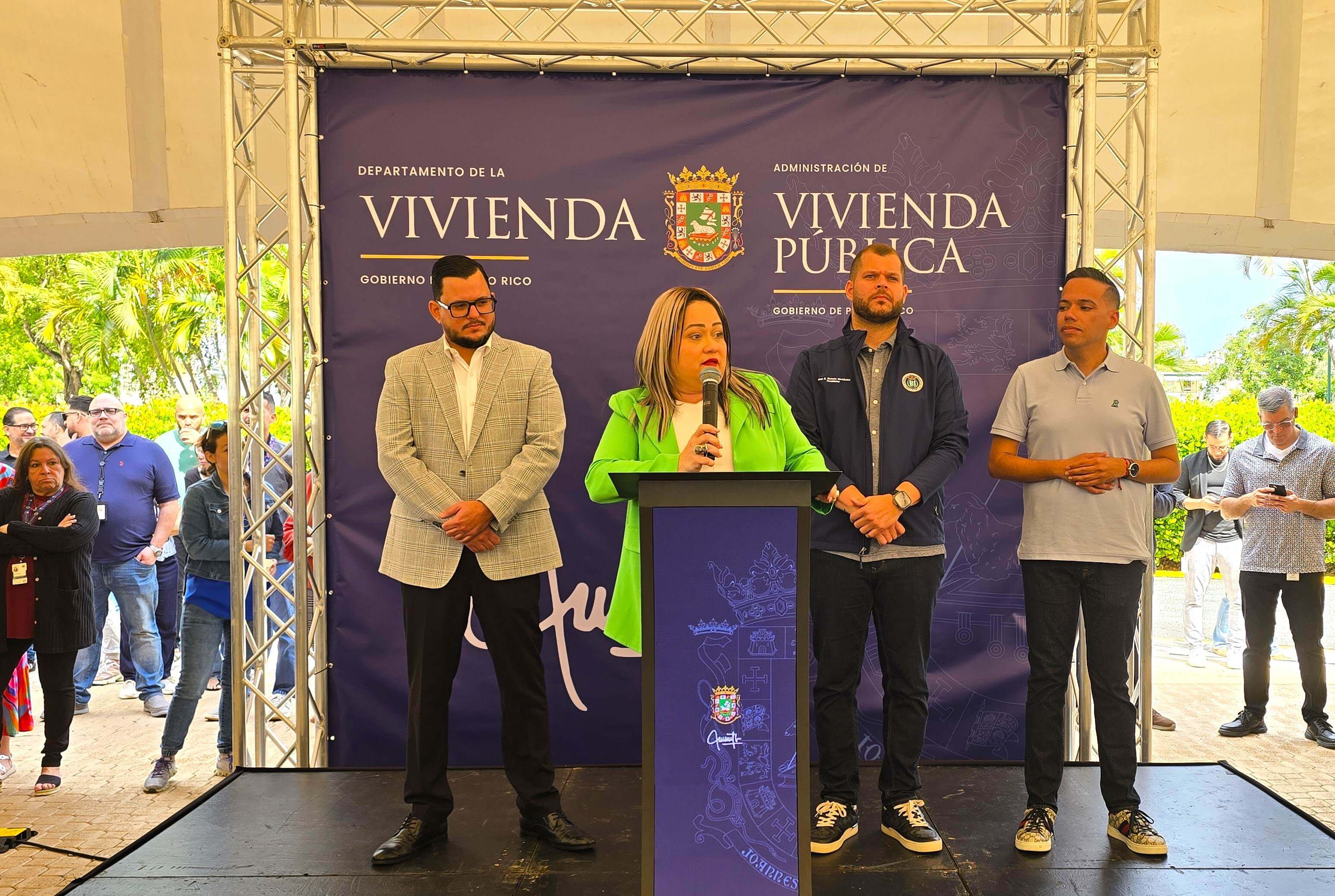 Ciary Pérez Peña hablando en el microfono, detras están Omar Figueroa, Juan A. Rosario y Alberto Fradera.