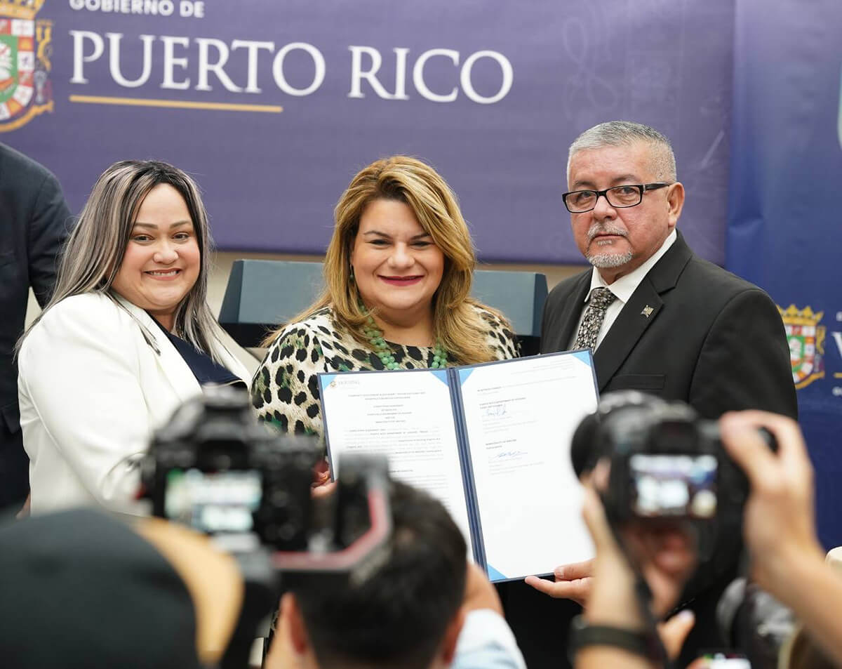 Governor Jenniffer González Colón, along with the Secretary of the Department of Housing, Ciary Pérez Peña, and another person holding the signed agreement.