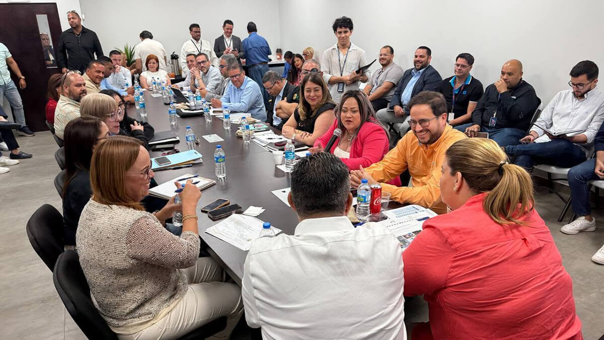 Governor Jenniffer González Colón, along with the Secretary of the Department of Housing, Ciary Pérez Peña, and several heads of central government agencies sitting and talking.
