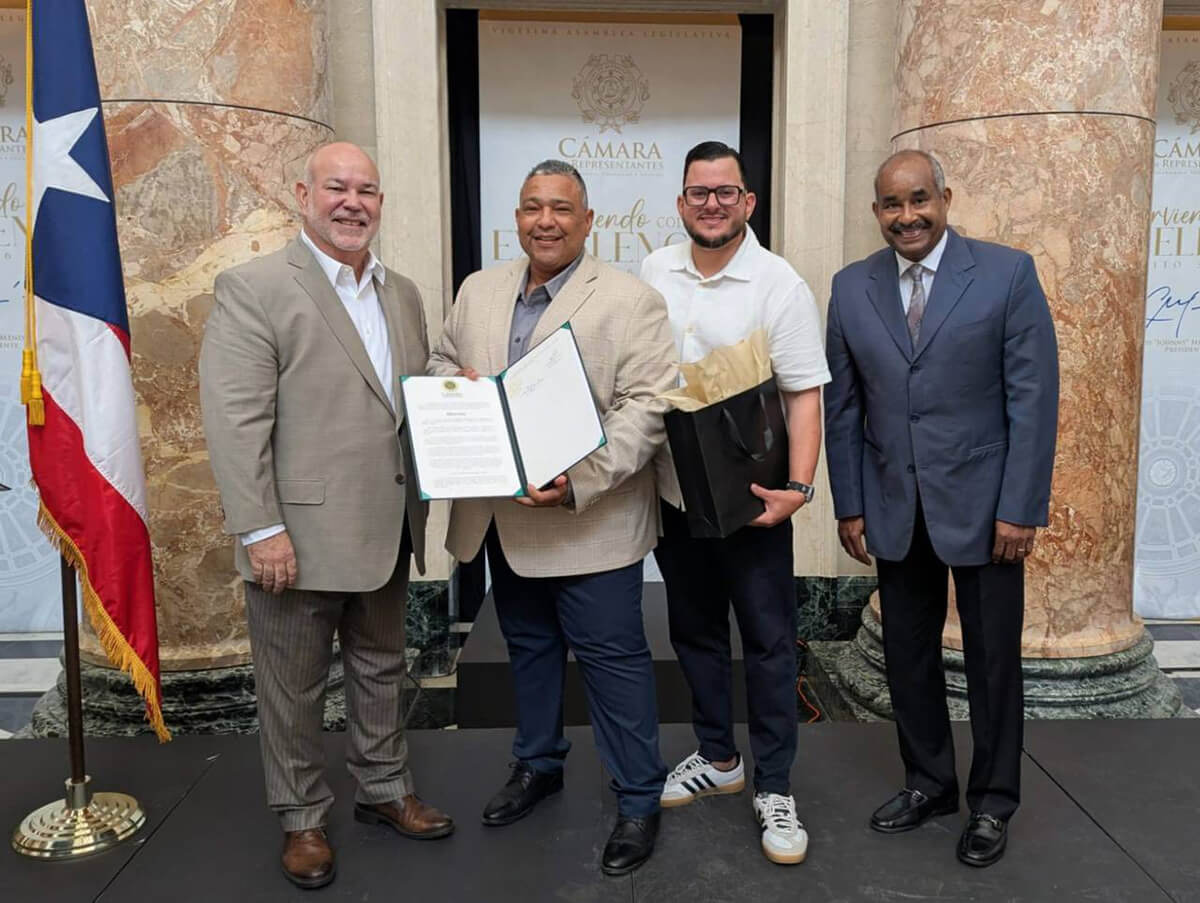 Persona aguantando el documento de reconocimiento que le dieron en el homenaje junto a tres servidores públicos.