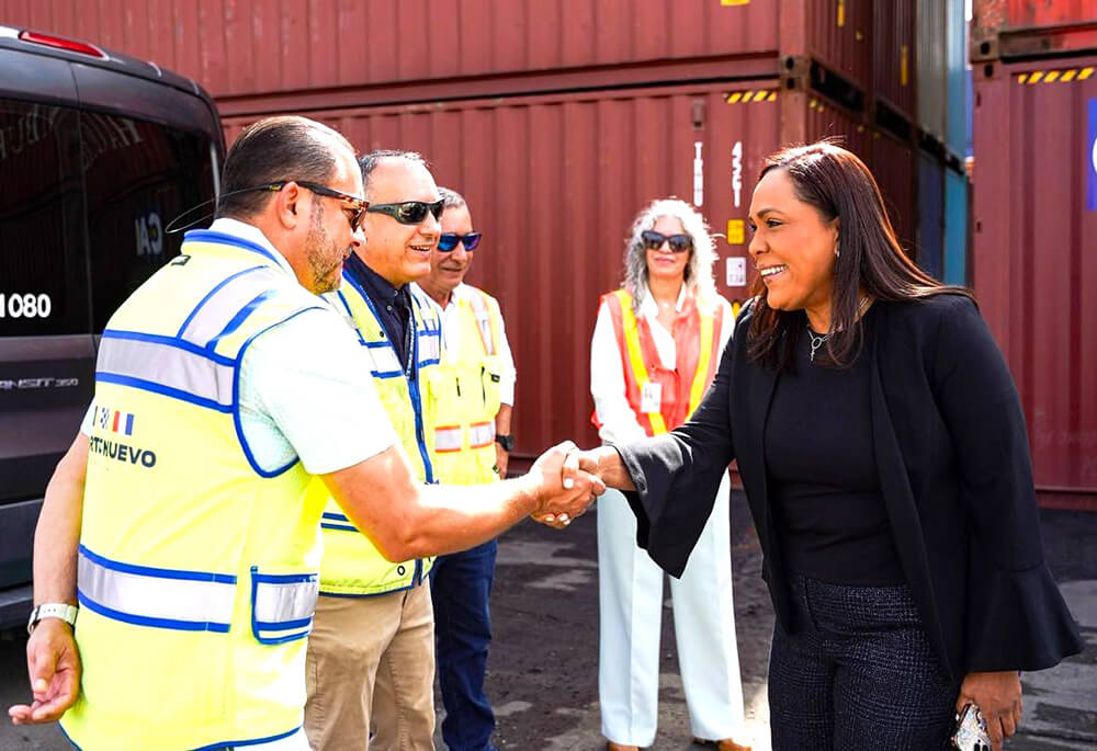La secretaria Rosachely Rivera Santana en foto saludando a empleados del puerto.