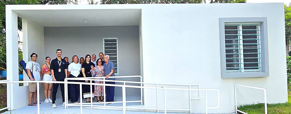 Photo of the elderly couple and government officials on the marquee of the house.