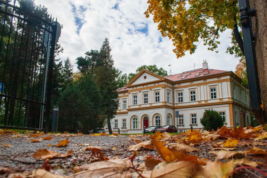 Castle Hostavice with park and garden surrounded by meadows and chestnut trees.
