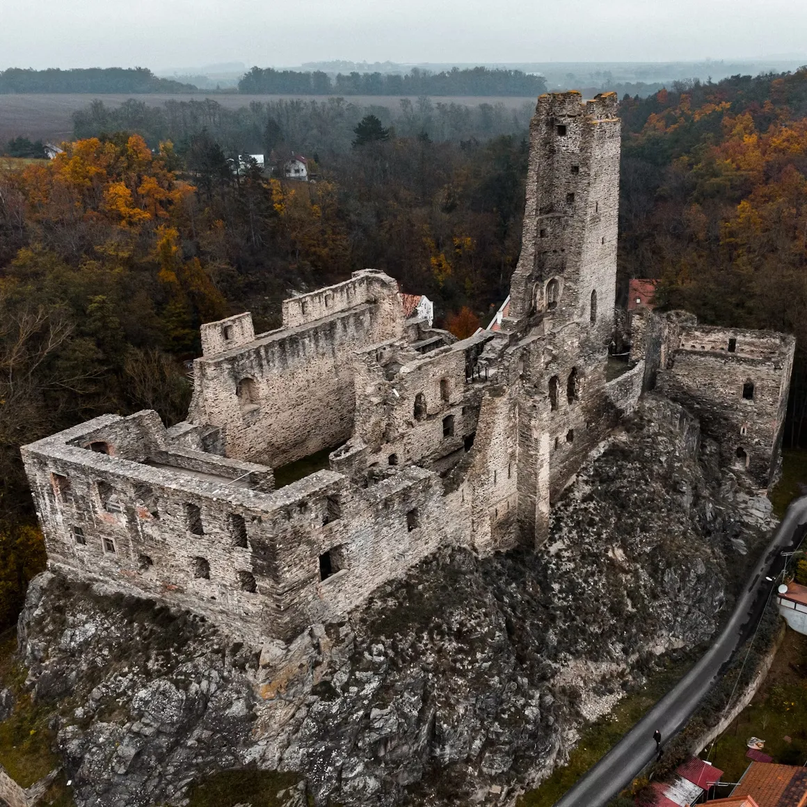 Ruins of Gothic Okor Castle with tall stone walls.