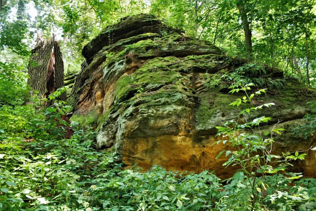 Baroque Vinor Castle with sandstone rock formations nearby.
