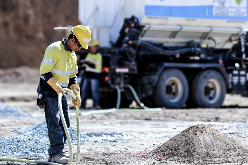 Orica on-site mining services operator beside a bulk explosives delivery vehicle