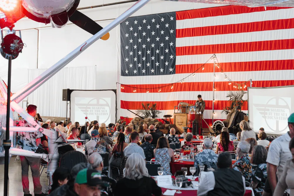 People enjoying a patriotic event at Soaring by the Sea Foundation's hangar