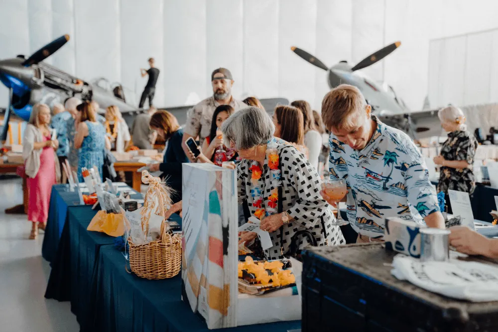People looking at memorabilia during an event at Soaring by the Sea Foundation's hangar
