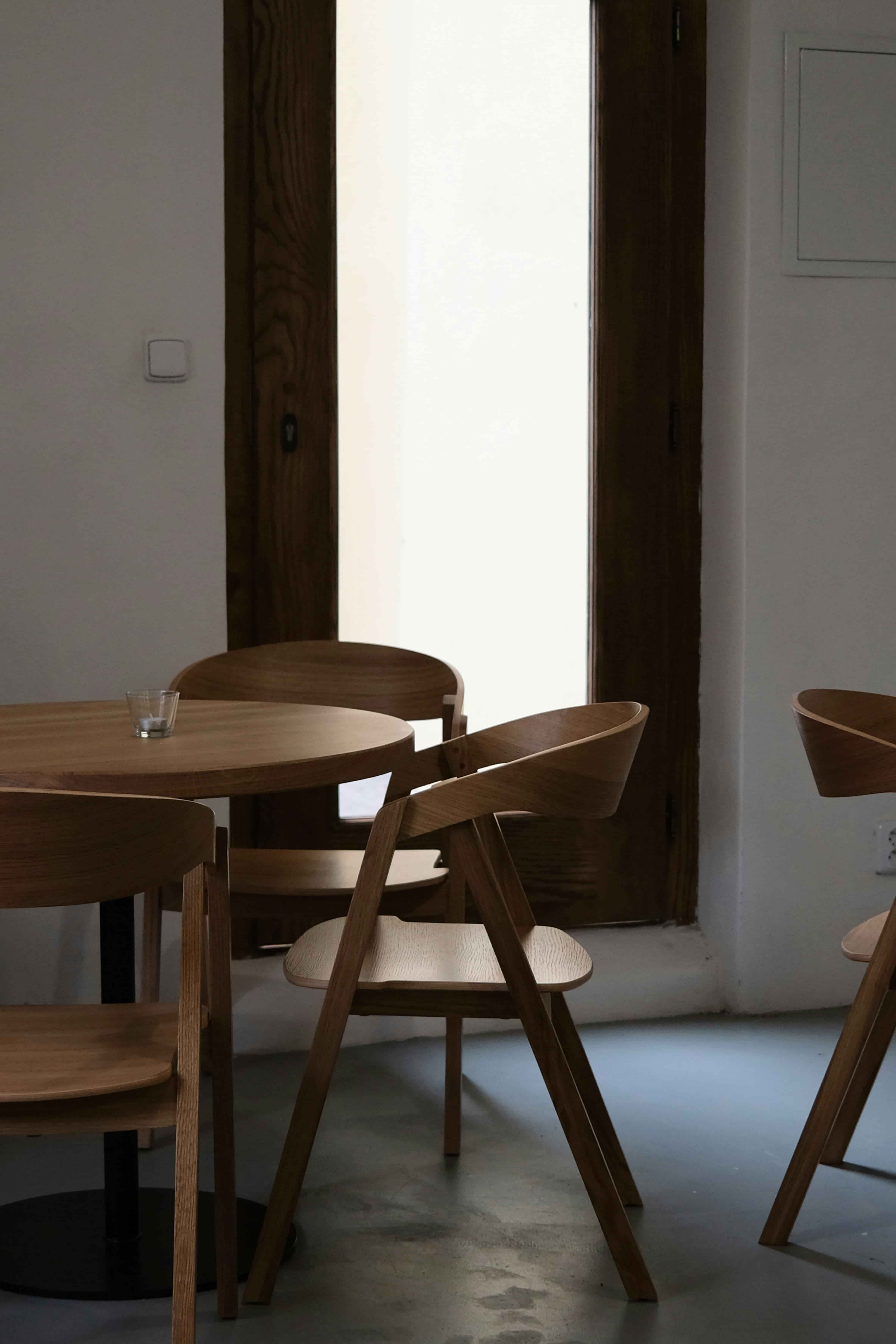 A wooden chair with a glass on the table.