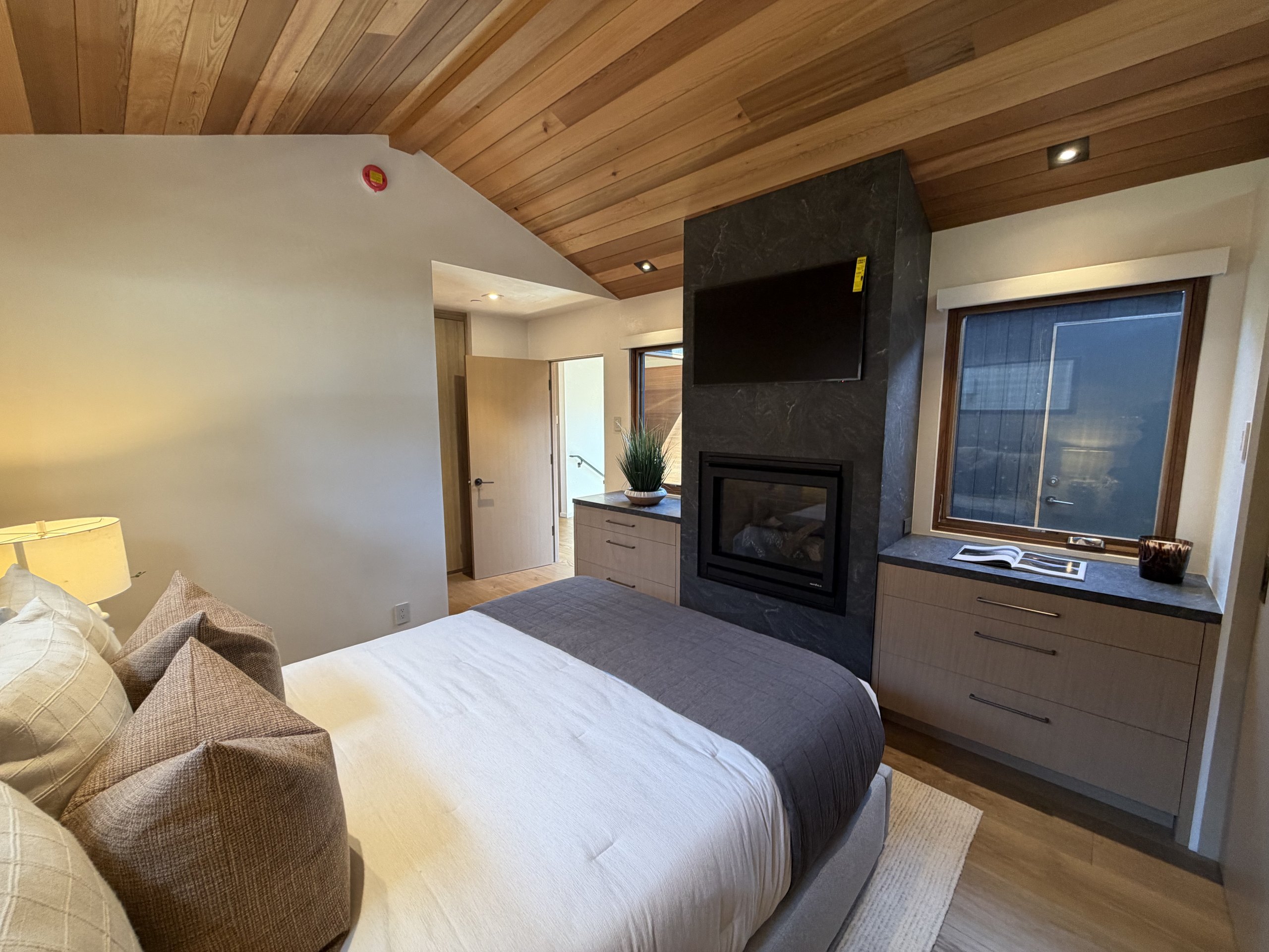 Bedroom at Brisa with stone fireplace and built-in cabinetry
