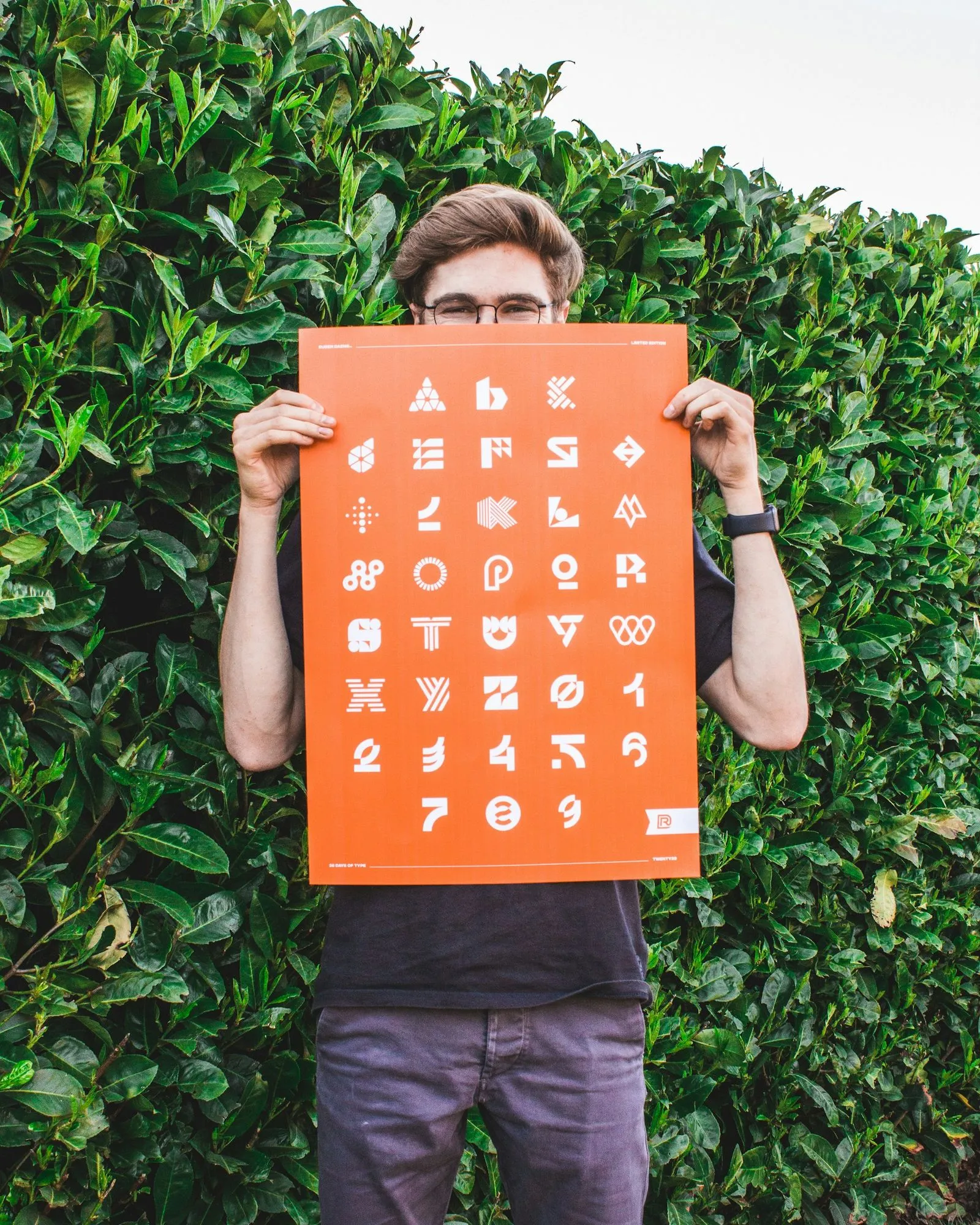 A man holding up a sign with a lot of symbols on it.