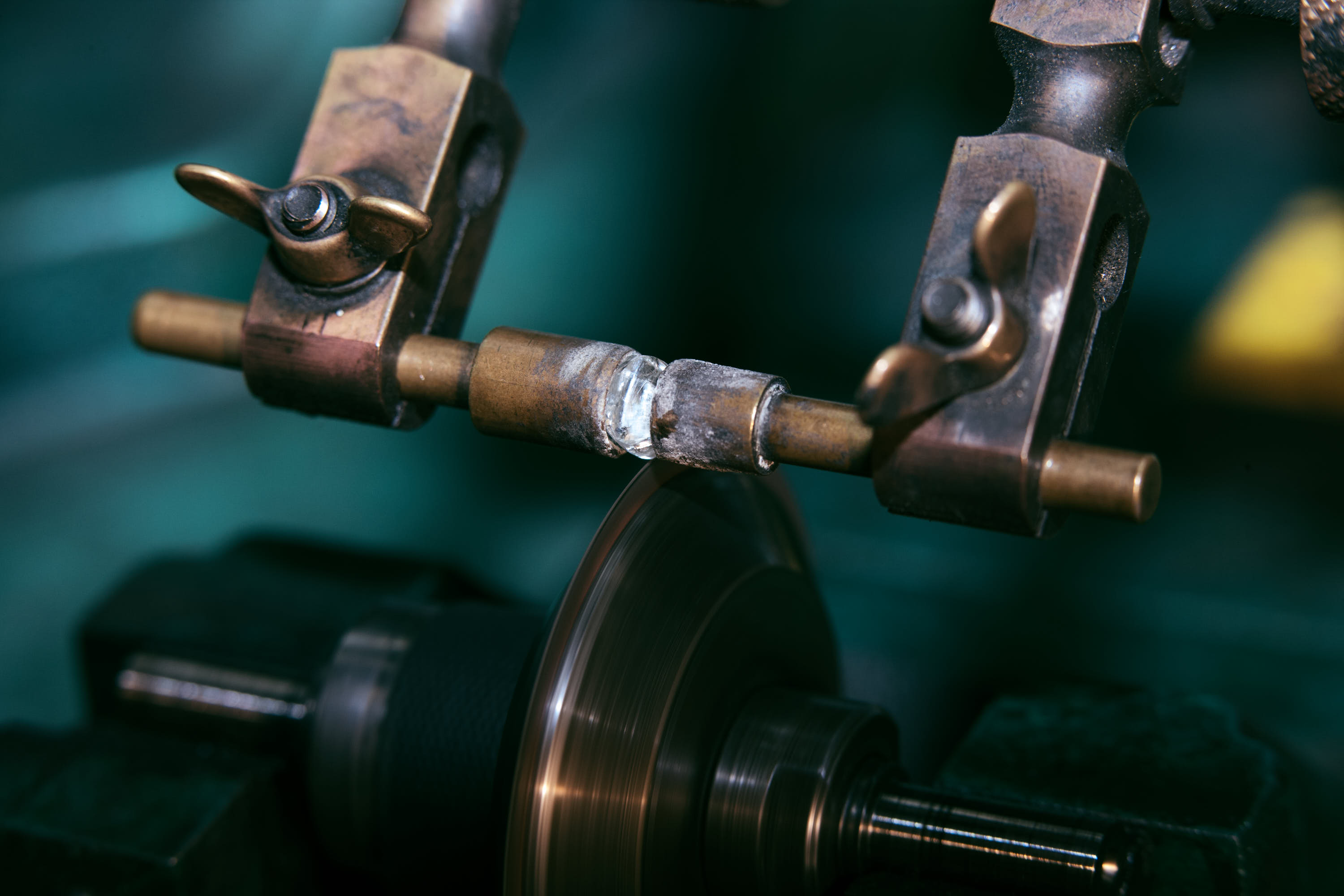 Nahaufnahme einer Metallbearbeitungsmaschine, die eine rotierende Scheibe verwendet, um ein Messingrohr zu bearbeiten.