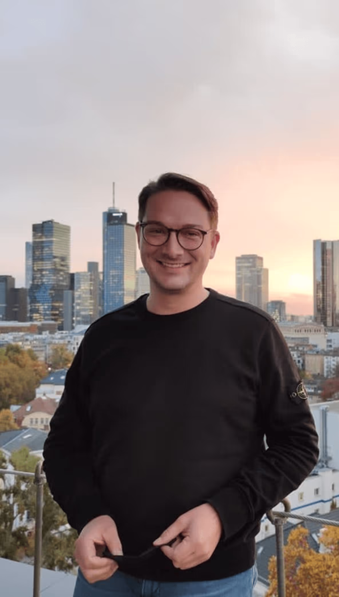 Mann vor Stadtpanorama – spricht über Vorteile der Immobilieninvestition mit Asconda