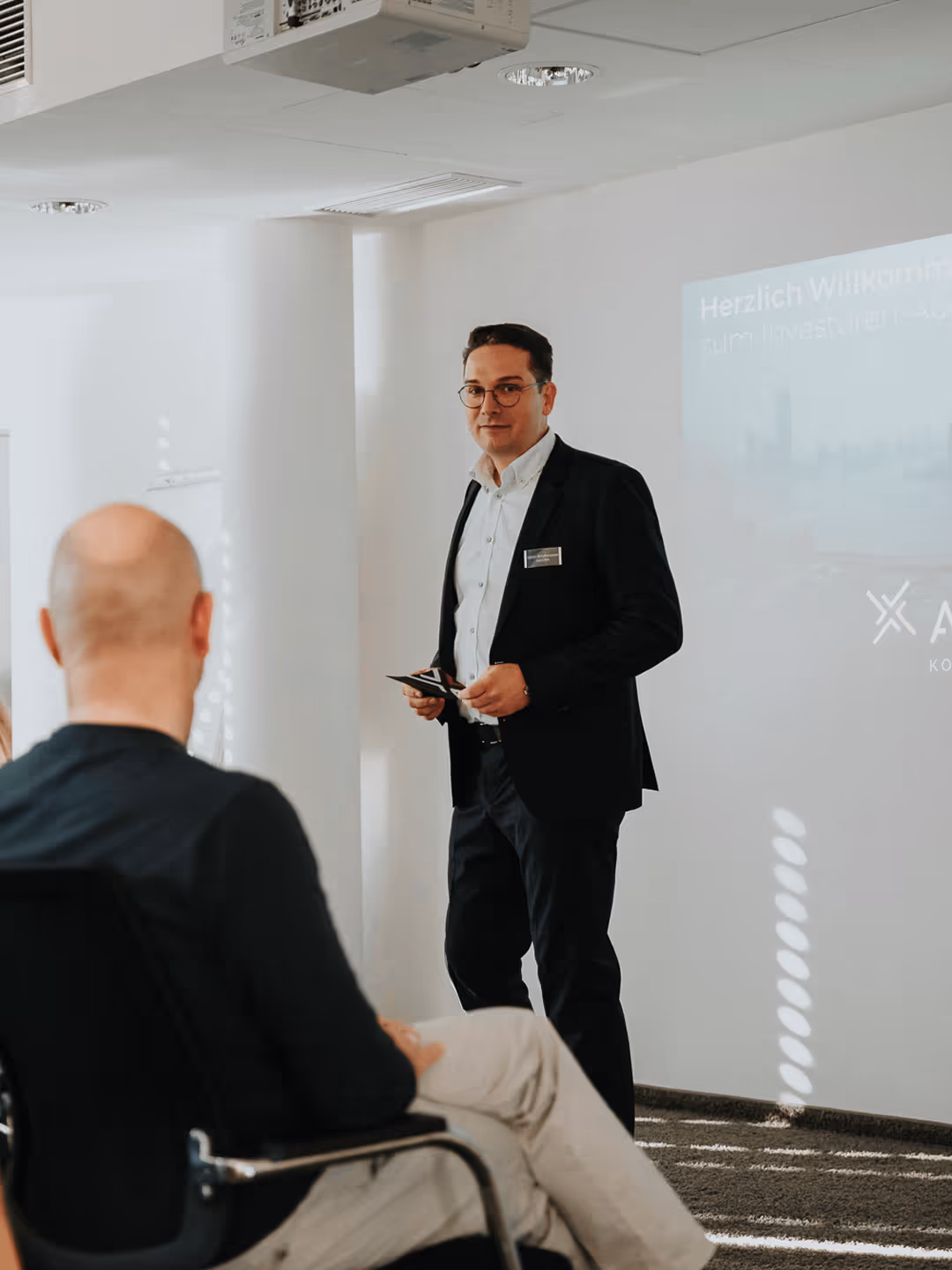 Drei Geschäftsleute im Gespräch in einem hellen Konferenzraum