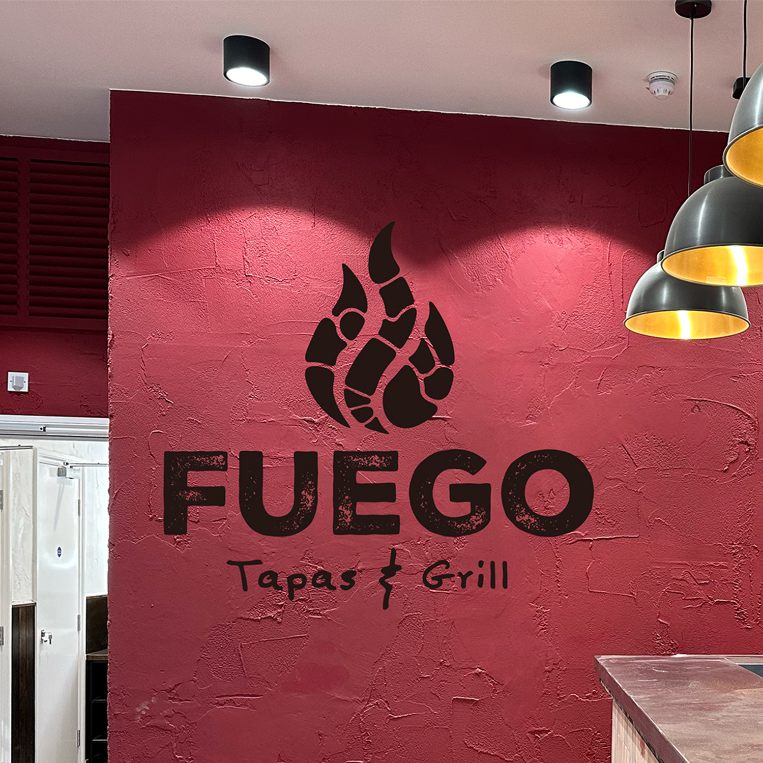 Wall mural of logo painted on red wall, created by Printshop MK, Milton Keynes