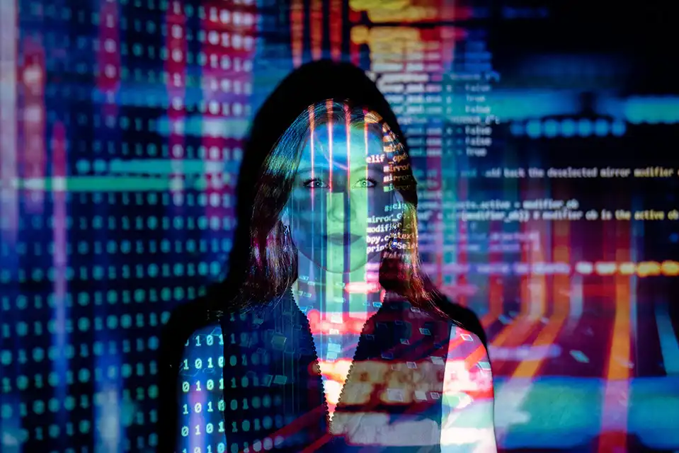Woman with programming code projected onto her face, representing the contrast between AI-generated visuals and human-crafted creative work.
